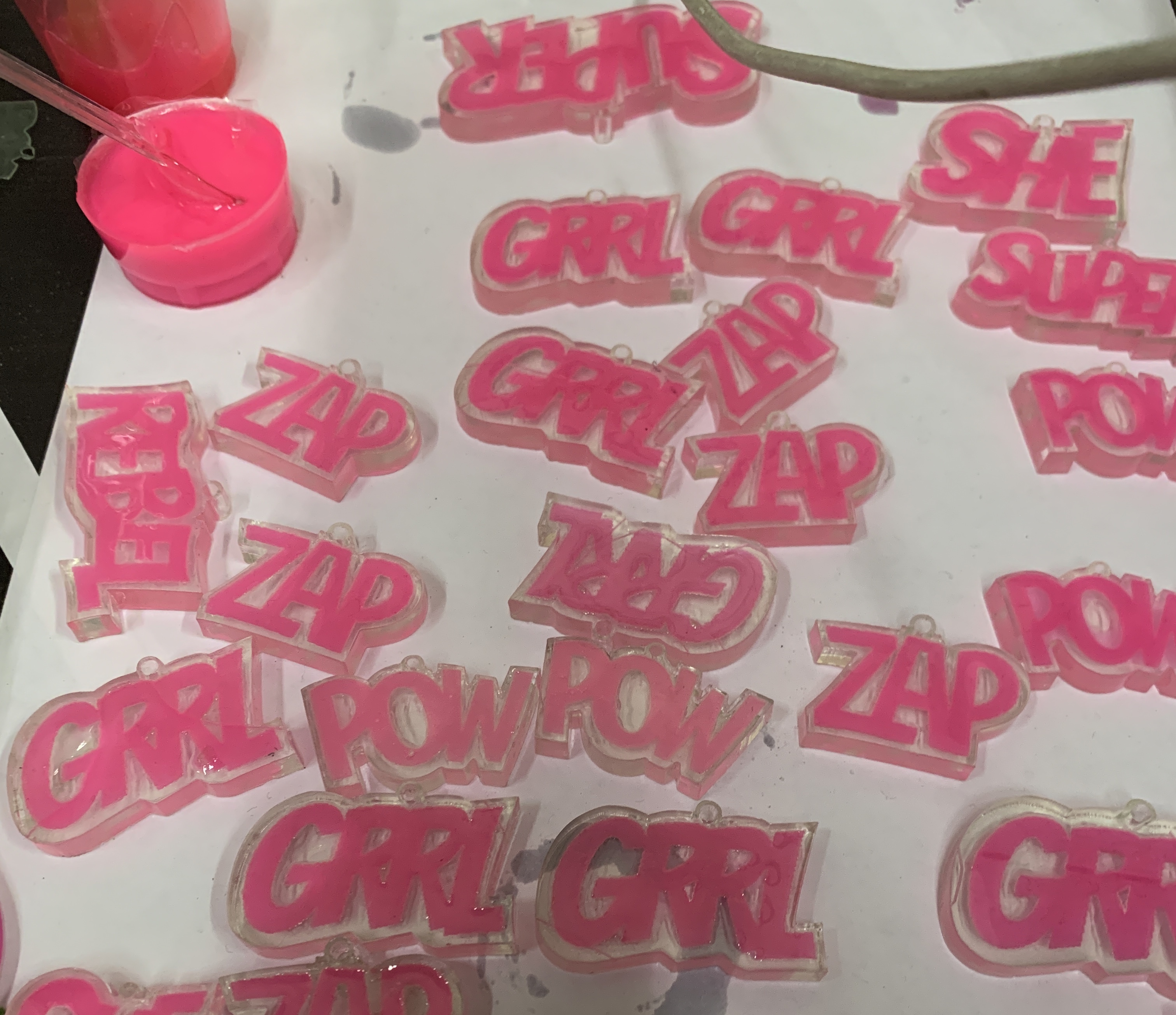 unfinished earrings in clear acrylic with comic book style action words in neon pink